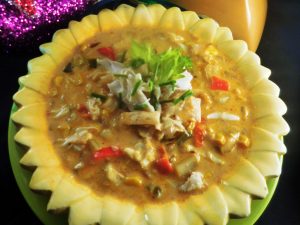 Cajun Crab Chipotle Corn Chowder in a Bowl Shaped Like a Sunflower over a Green Plate