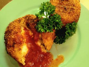 Crab Arancini with a Parsley Garnish on a Lime Green Plate