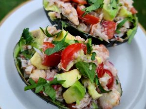 Crab Avocado Salad Served in Avocado Halves on a White Plate