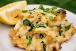 Lump Crab Cake on a white plate with a lemon wedge